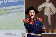 Schauspielerin im Käpt'n Book- Kostüm mit einem Mikrofon in der Hand.